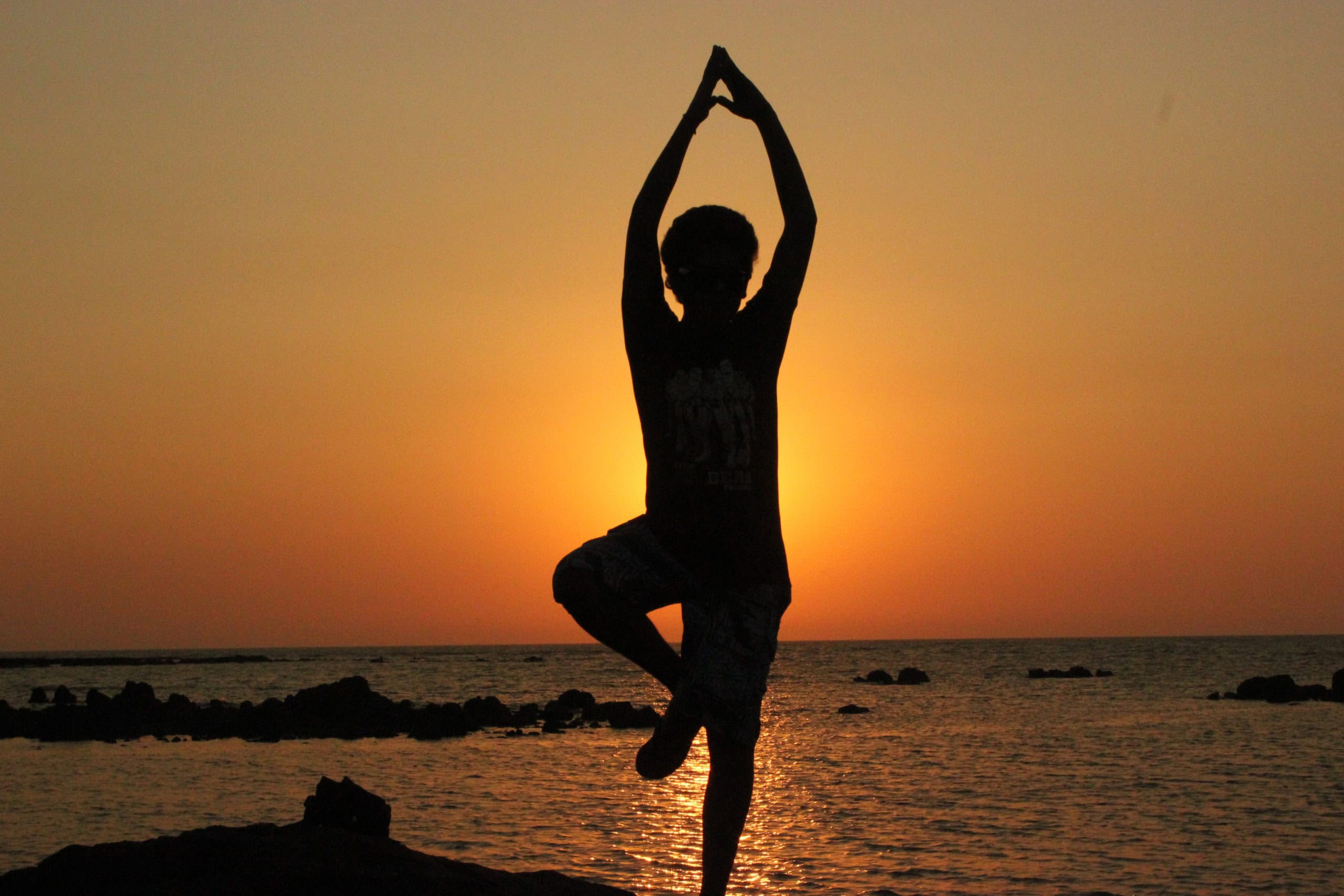 Yoga for Begyndere ved Havet Person i yoga position ved solnedgang ved havet.