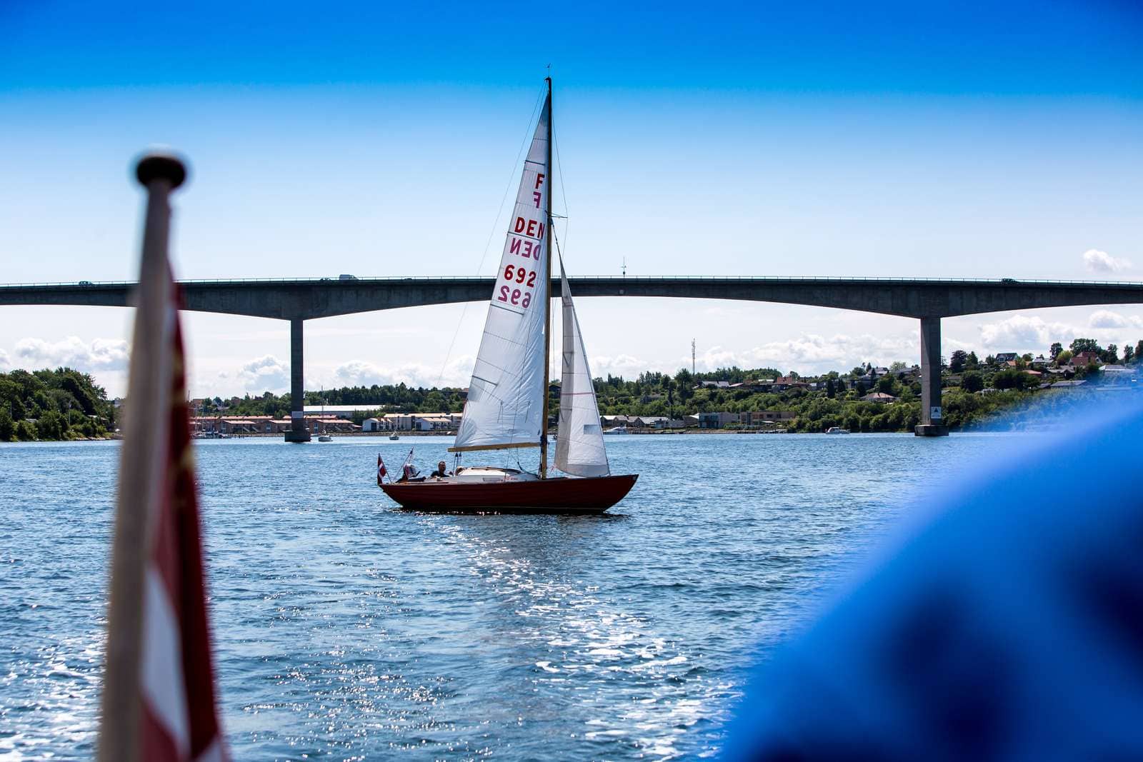 Sønderborg yacht sejlads under broen med klar blå himmel.