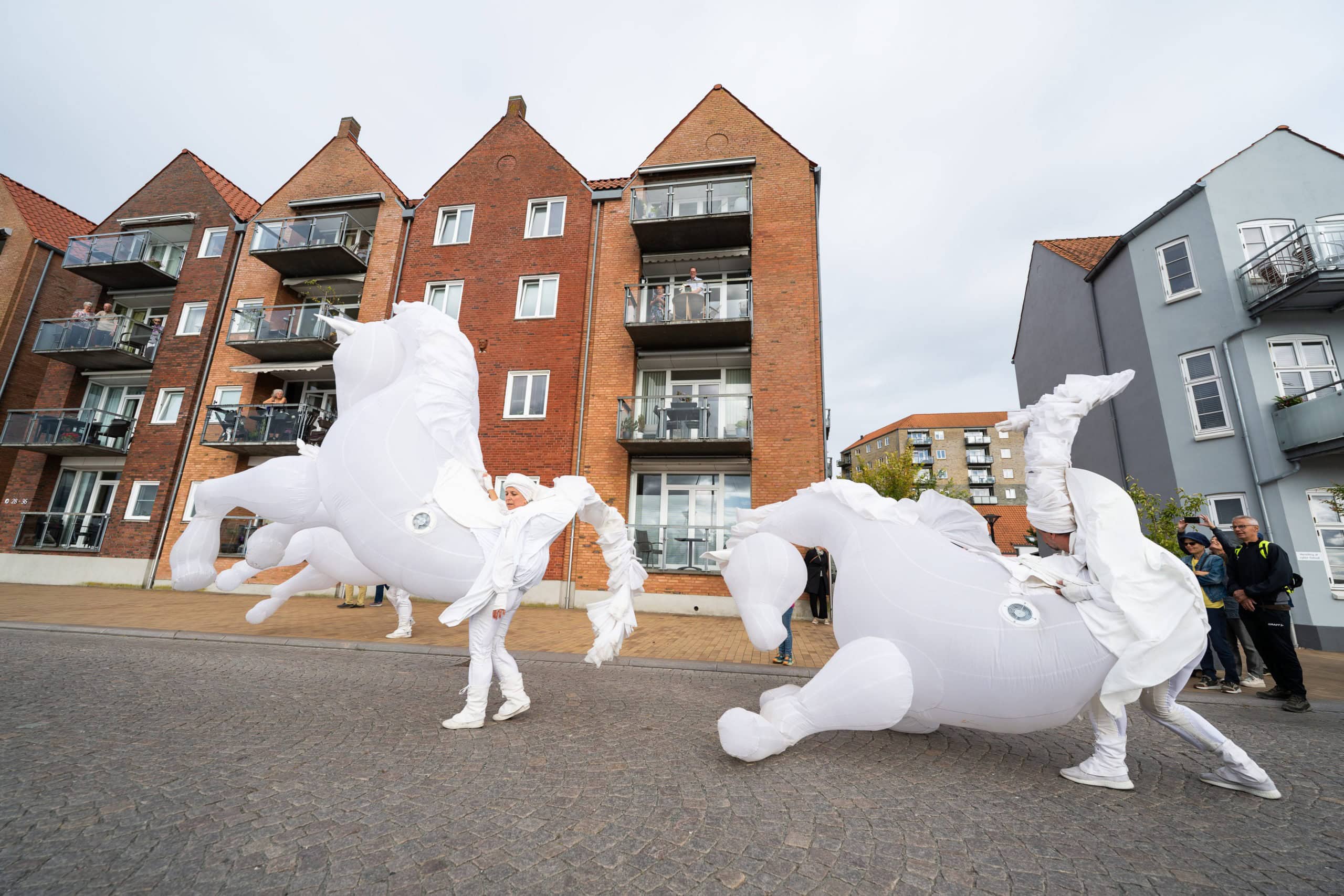 Folk i fantasifulde kostumer under gadeteaterfestival i Sonderborg.