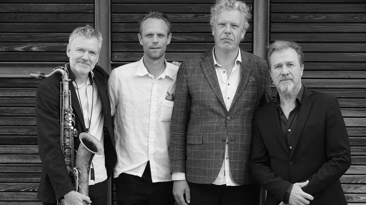 Jazzmusikere fra Sønderborg Jazzclub foran en trævæg.