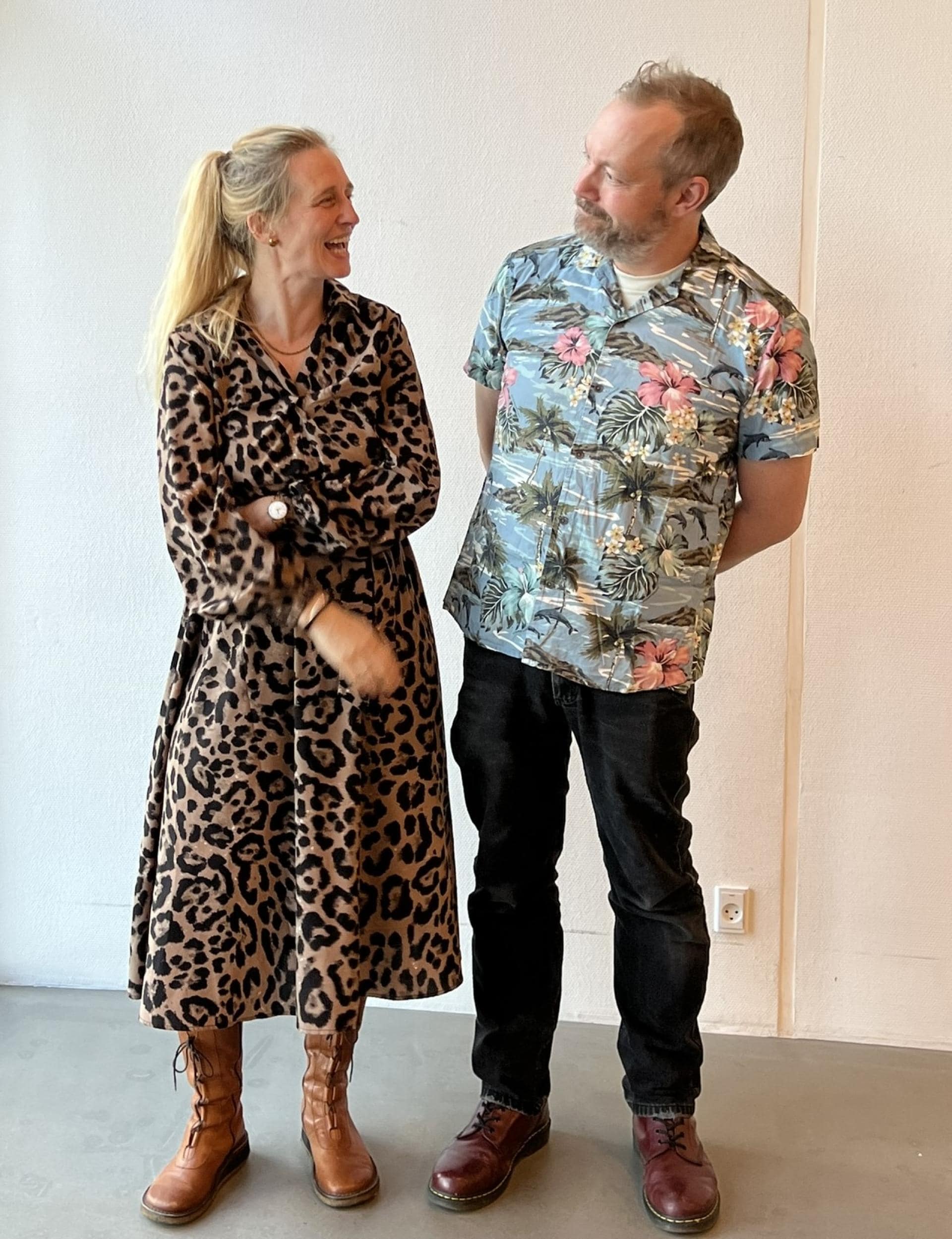 To personer snakker og griner i et rum.