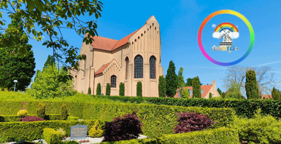 Sønderborgs Christianskirke med smuk have og blå himmel.
